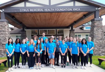 23 Teens in blue YOuth Leasership t-shirts in front of Citrus Memorial Health Foundation YMCA