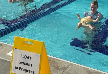 Instructors teaching toddlers to swim in the YMCA of the Suncoast pool.