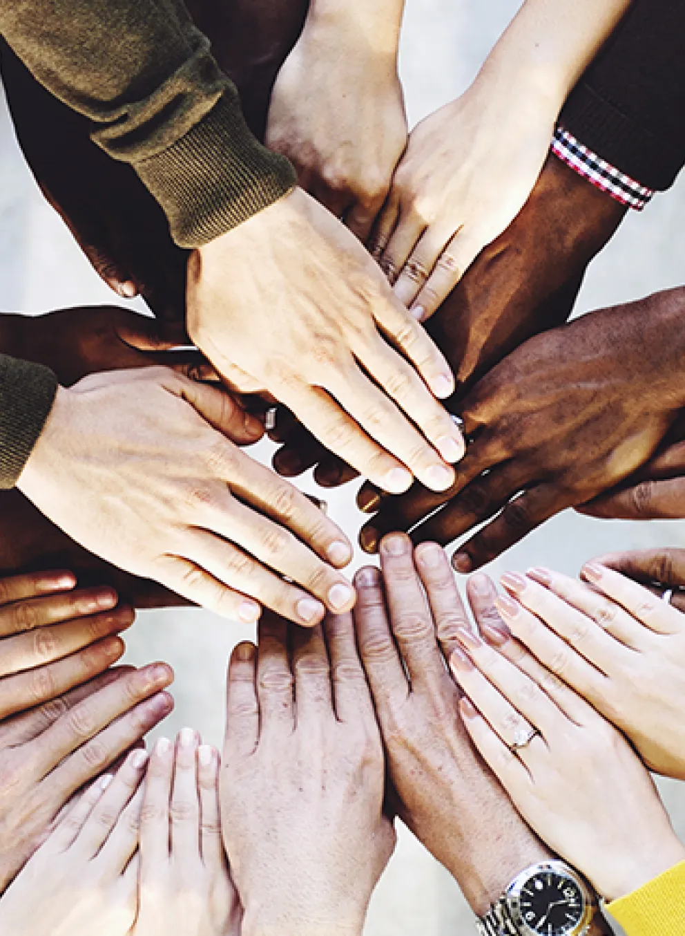 diverse group huddled with hands in the middle