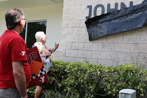 John Geigle removing banner over his namesake sign 