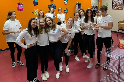 group of teens wearing white shirts and black pants volunteering at gratitude dinner