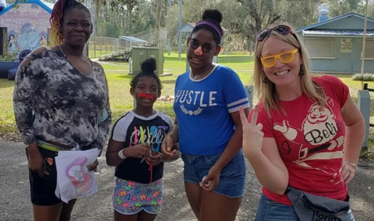 one family at the 2021 Hernando Y Looney Tunes event. Two children and two adults at the park, posing for the camera.