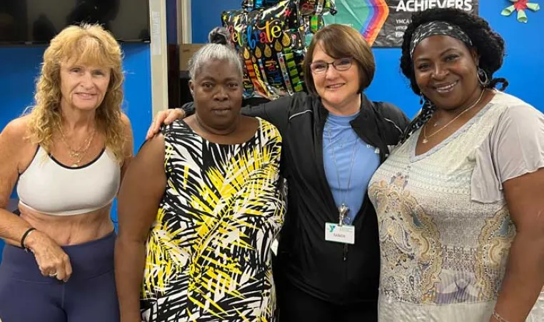 Four women involved with the Healthy You Initiative pose for a photo inside the Greater Ridgecrest YMCA.