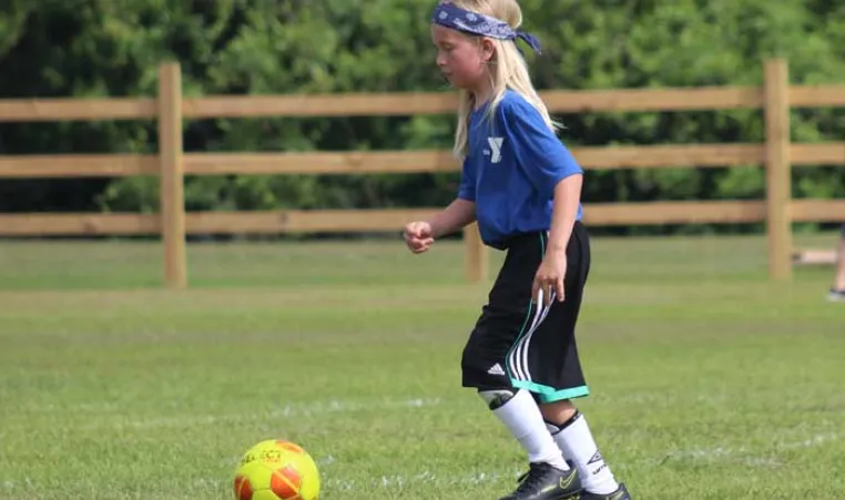 one child playing soccer outdoor field