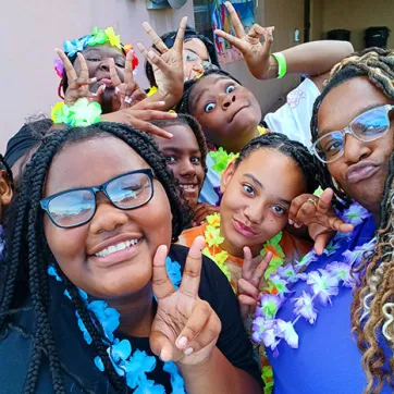 BTAG Participants pose for photo. They are wearing leis and making a peace sign.